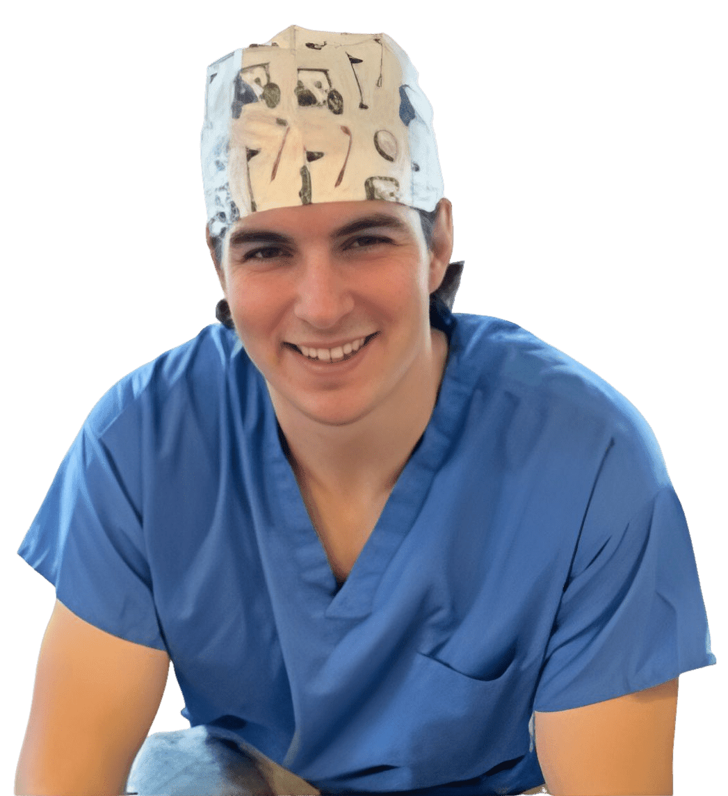 Smiling medical professional in blue scrubs and patterned surgical cap.