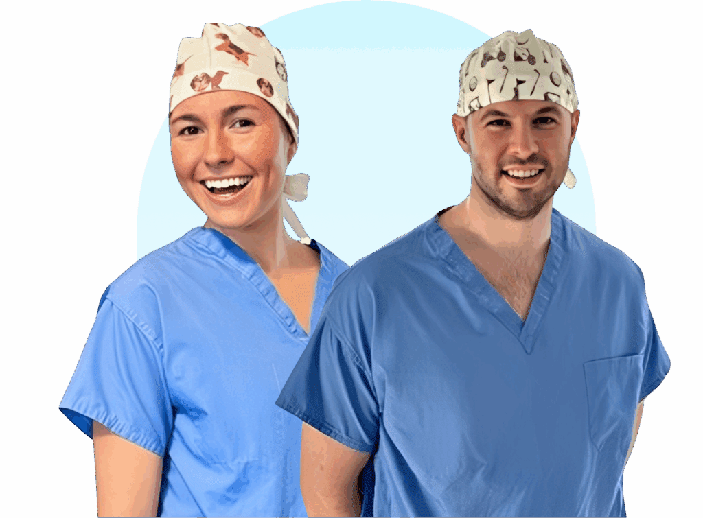 Two medical professionals in colorful surgical caps and scrubs smiling.